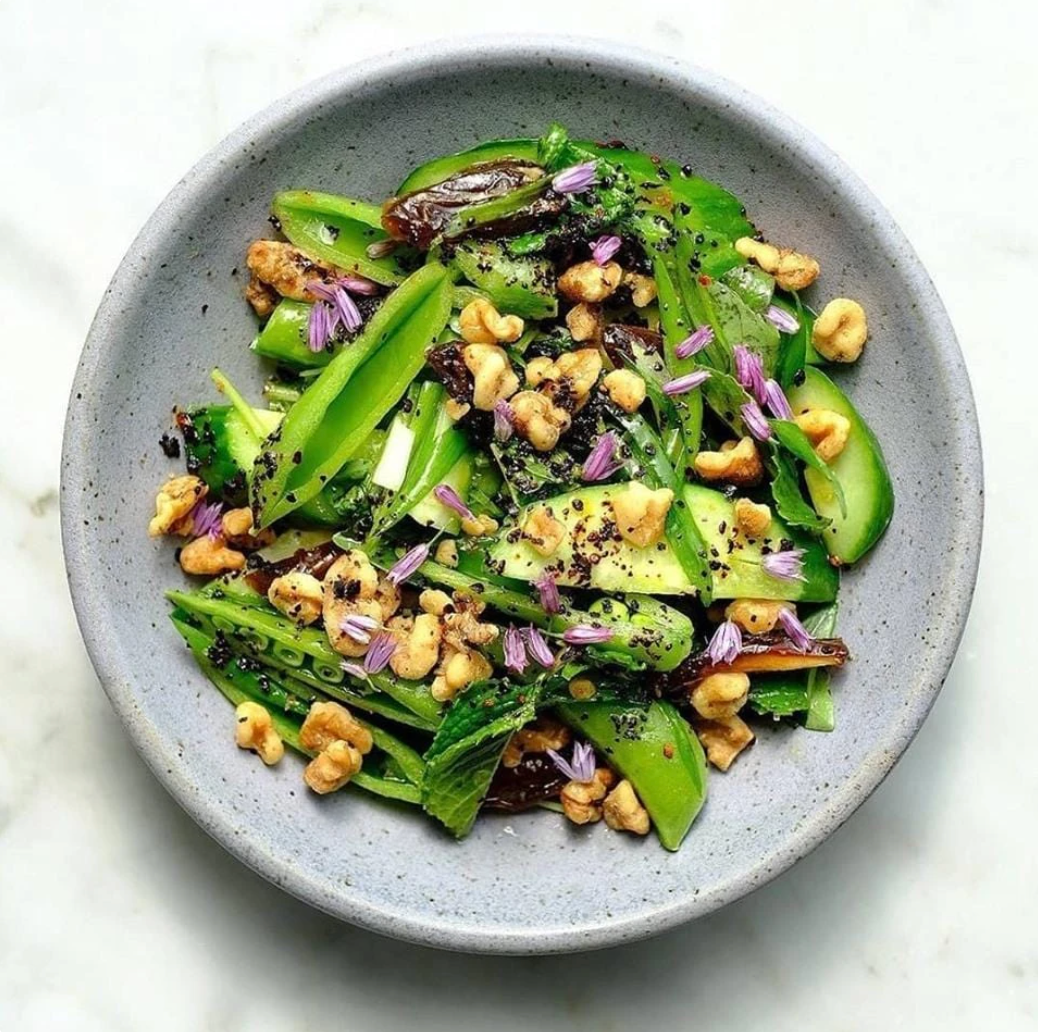 Bowl of pea pods & nuts sprinkled with Urfa chili spice