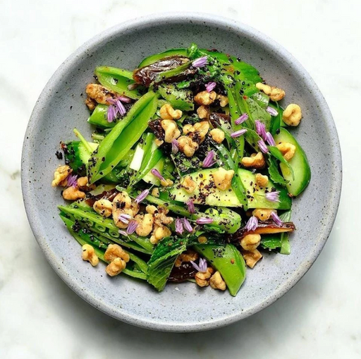 Bowl of pea pods & nuts sprinkled with Urfa chili spice