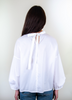 Back view: Female model wearing a white semi-sheer popover shirt with puffy long sleeves and grosgrain ribbon tie