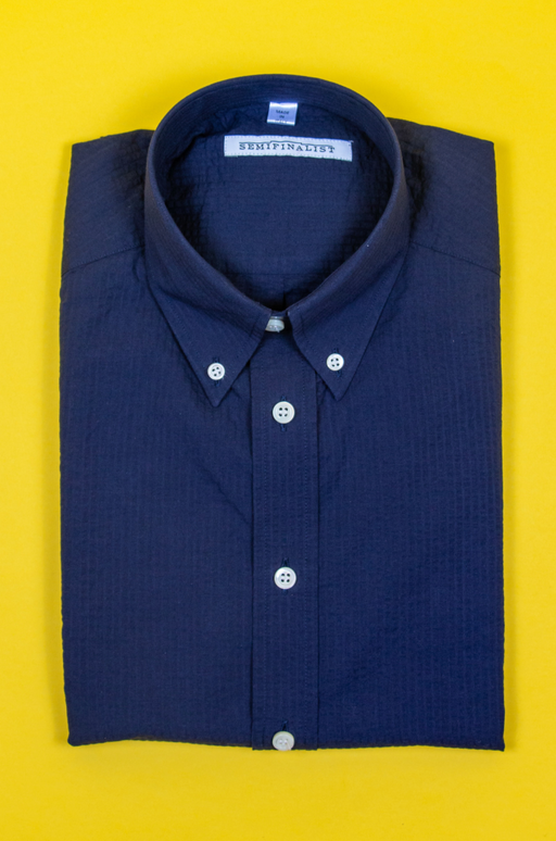 Blue short sleeve collar shirt with white buttons, folded