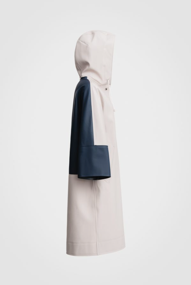 Side view: White hooded raincoat with navy back panel and  sleeves