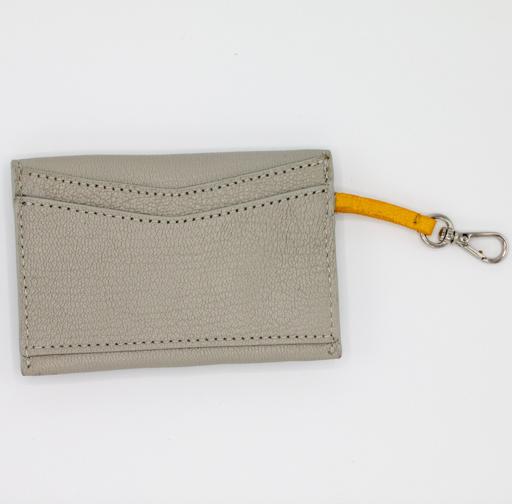 Two rear pockets on grey leather card case with yellow clip strap