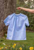 Short sleeve blue gingham shirt with ruched neckline on hanger