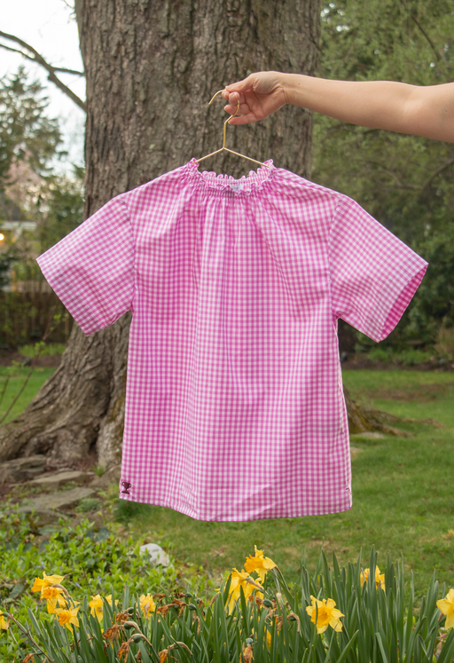 Short sleeve pink gingham shirt with ruched neckline on hanger