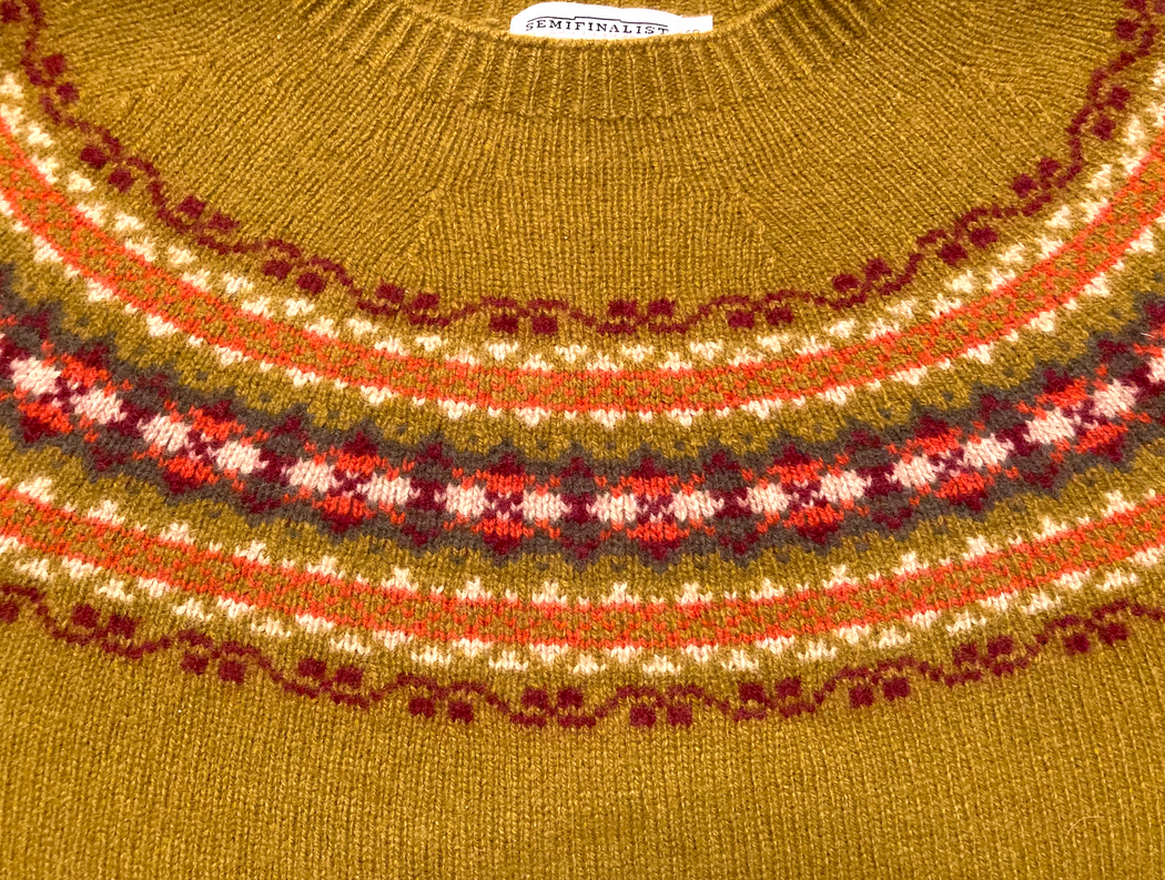 Red/burgundy/cream geometric yolk pattern on olive green sweater