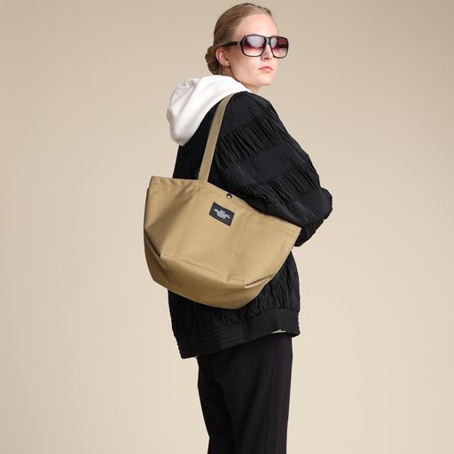 Female model wearing khaki colored Small Carry-All Tote on her shoulder
