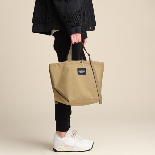 Female model holding khaki colored Small Carry-All Tote in her hand