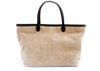 Tan suede tote with black leather trim and handles