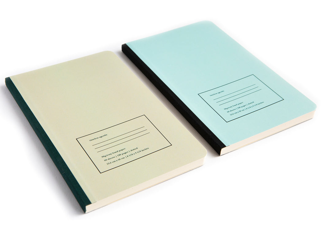 Two agenda notebooks, side by side, one tan and one light blue