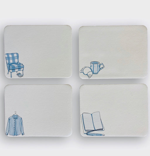 4 white note cards with blue illustrations on bottom left corner: an upholstered chair & slippers, a croissant & coffee mug, a striped shirt, and a journal & pen
