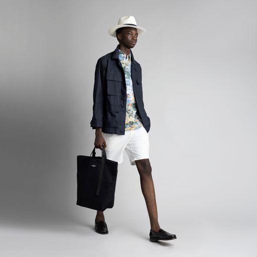 Male model holding the Black Carry-All Tote by the handles