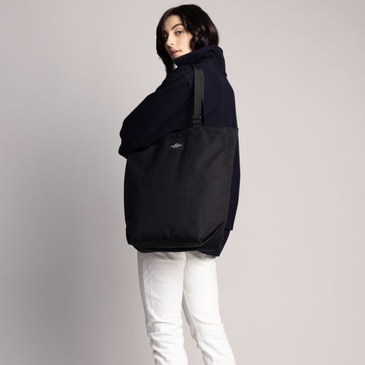 Female model wearing the Black Carry-All Tote as a shoulder bag