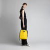 Female model holding yellow Mid Side Handle Tote by top handle
