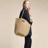 Female model wearing the Khaki Carry-All Tote as a shoulder bag